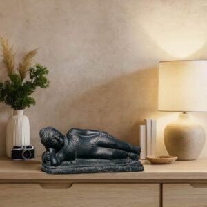 Statue Bouddha couché en pierre – 40 cm Noir antique - La statue est mise en avant sur un meuble pour une déco intérieure zen (Mise en situation générée à titre indicatif - visuels non contractuels)