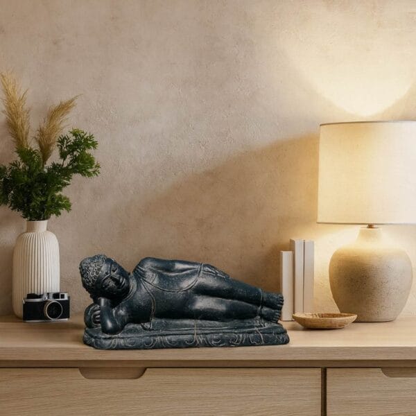 Statue Bouddha couché en pierre – 40 cm Noir antique - La statue est mise en avant sur un meuble pour une déco intérieure zen (Mise en situation générée à titre indicatif - visuels non contractuels)