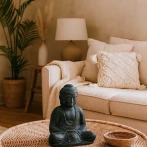 Statuette Bouddha assis en pierre – 21 cm Méditation - La statuette est posée sur une table basse dans un salon à la décoration bohème chic