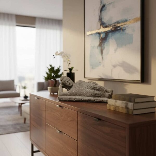 Statue de Bouddha allongé couché en pierre volcanique – 50cm La statue est posée sur un buffet en bois mettant en avant une déco zen