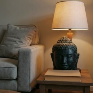 Statue tête de Bouddha Urna - Noir antique 35 cm - Posée sur une table d'appoint, ambiance cosy (Mise en situation générée à titre indicatif - Visuel non contractuel)