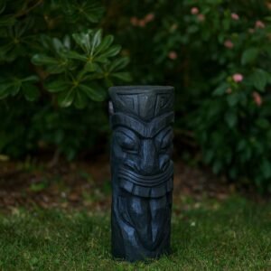 Statue Maori totem Tiki ton ciré noir 51 cm - La statue est posée en tant que décoration extérieure au bord d'un massif (Visuel non contractuel - Mise en situation générée à titre indicatif)