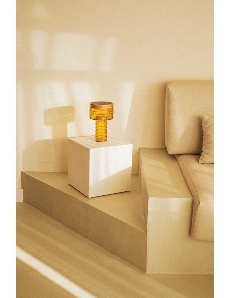 Lampe de table sans fil rechargeable Ambre Orange sur un cube blanc, exposée dans un cadre intérieur épuré