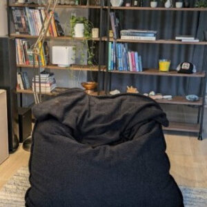 Coussin pouf géant anthracite dans un salon moderne avec étagères et plantes, référence produit D0118-A