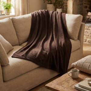 Couverture polaire 160x220 chocolat C0238CHOCO drapée sur un canapé dans un salon confortable