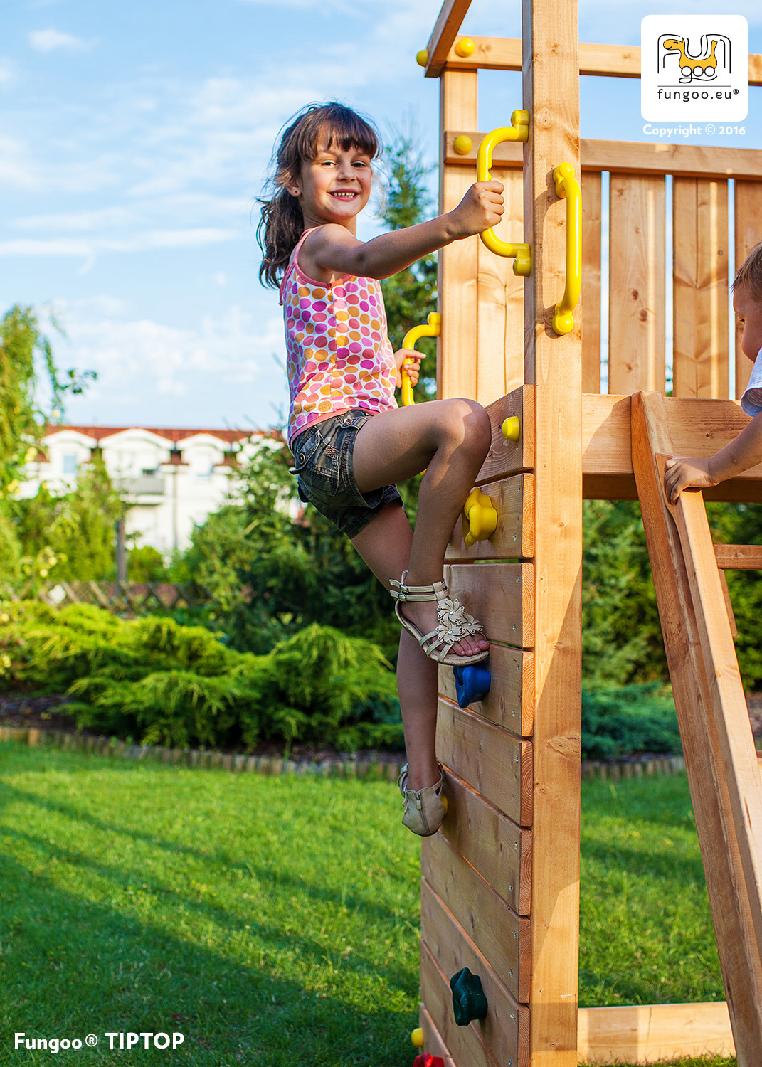 Enfant grimpant sur le mur d'escalade de l'aire de jeux géante FUNGOO RAINBOW FORTRESS TIP, référence 3513PT.