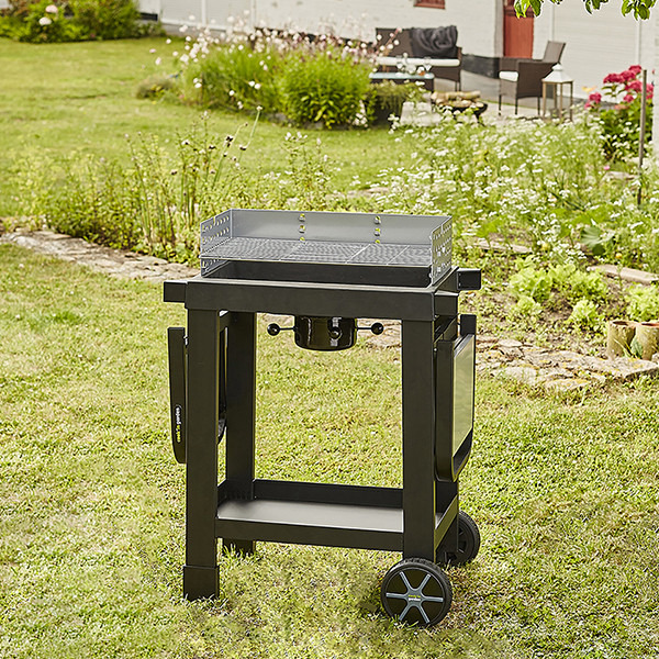 Image principale du barbecue à charbon en fonte EASY 60, référence CH042T, dans un jardin convivial.