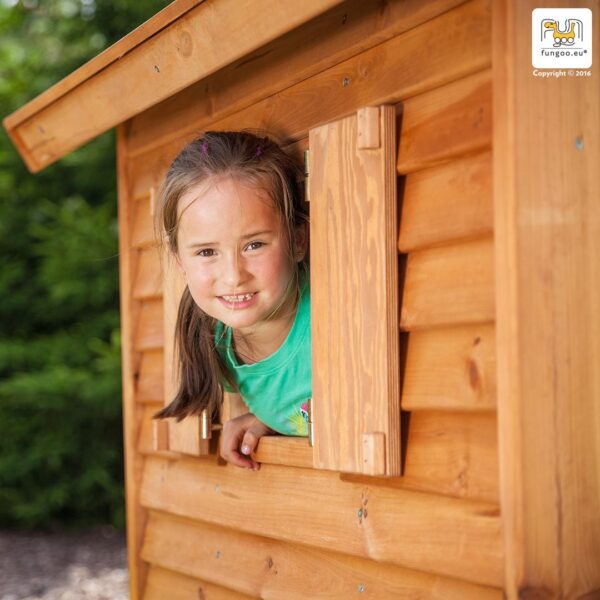 Enfant souriant regardant par la fenêtre de la cabane sur pilotis enfant, modèle FUNGOO MYHOUSE, référence 1075PT.