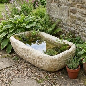 Abreuvoir en pierre, auge basse de 72 × 37 cm, en situation dans un jardin rustique, référence 280021